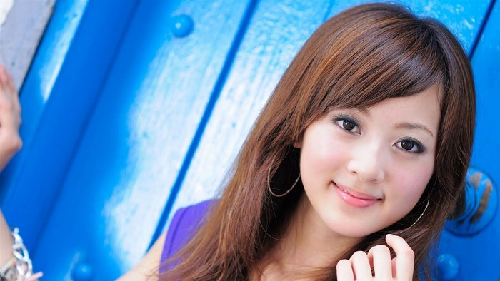 Young Korean woman with brown hair and hoop earrings