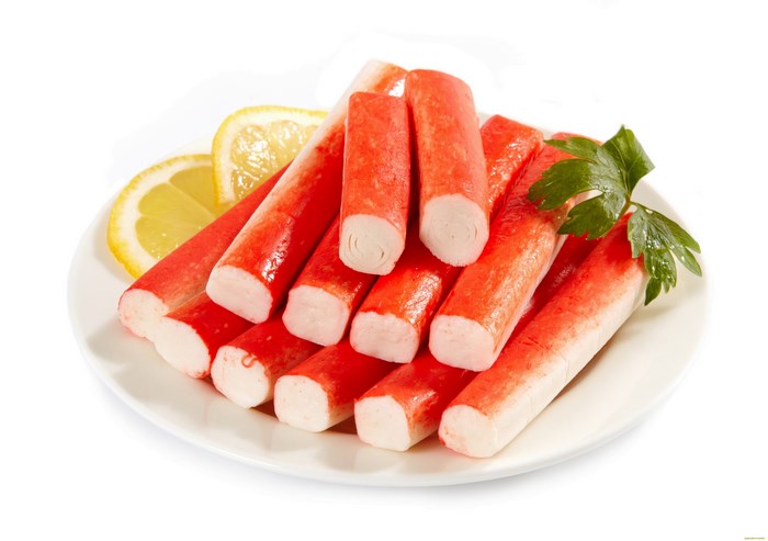 Crab sticks with lemon and parsley on a plate