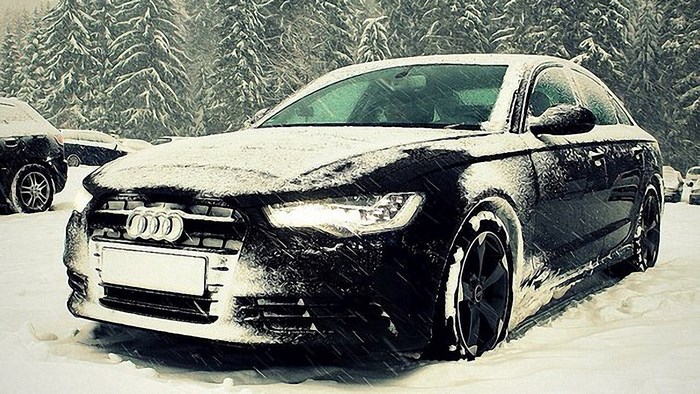 Audi car covered in snow in a forest
