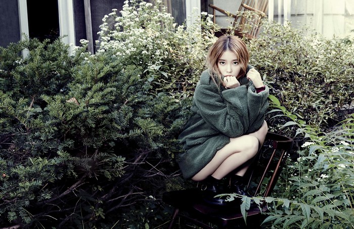 IU sitting in a garden