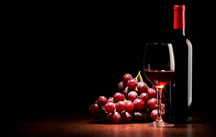 Elegant Red Wine Bottle and Glass with Grapes