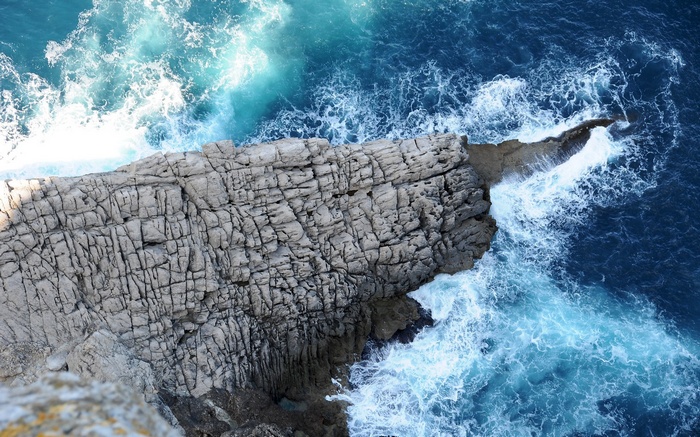 Waves crashing against a rocky cliff face