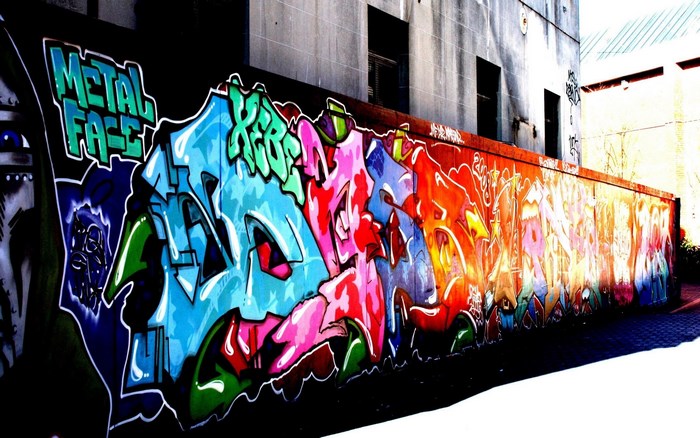 Graffiti art on a wall with "METAL FACE" text
