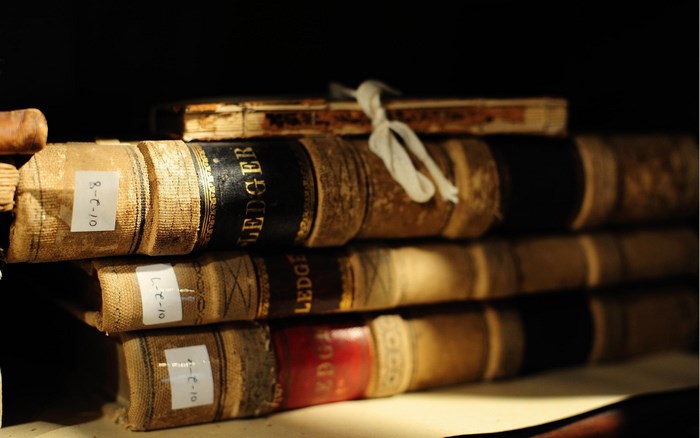 Stack of old ledgers on a shelf