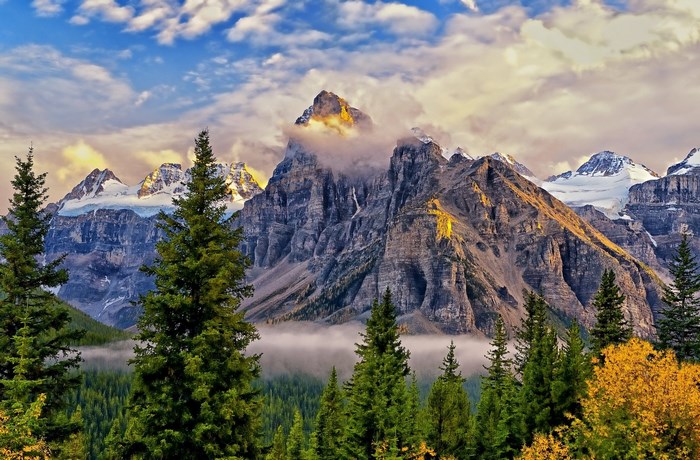 Mountain range with trees and clouds