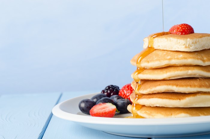 Stack of pancakes with berries and syrup
