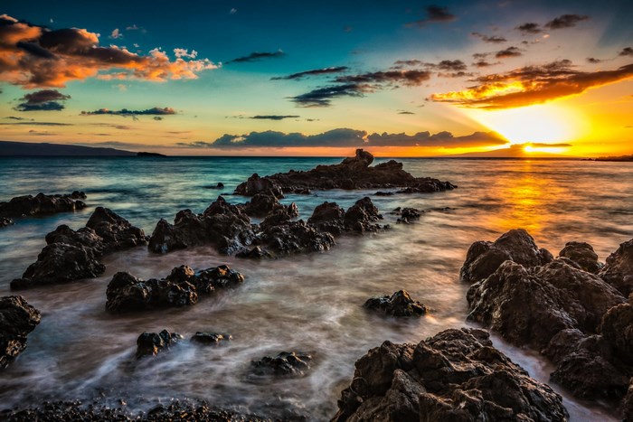 Rocky coastline at sunrise with ocean waves
