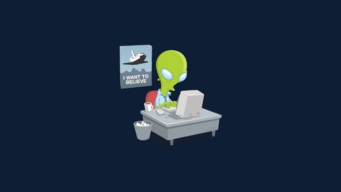 Alien at Desk with "I Want to Believe" Poster