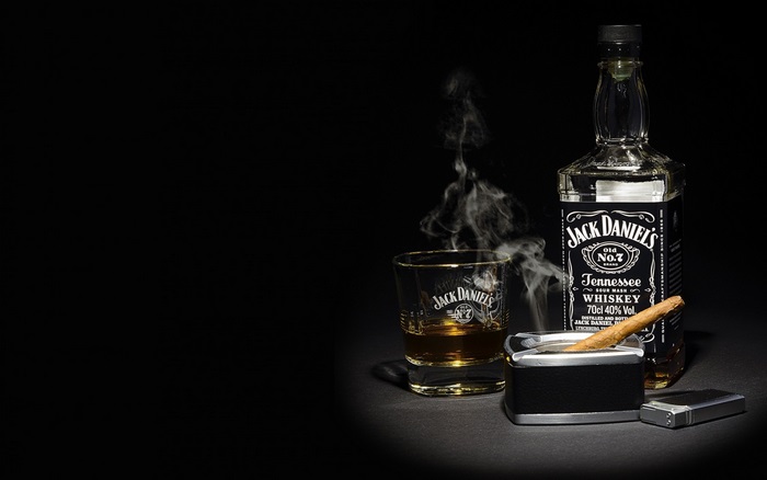 Jack Daniel's Whiskey bottle, glass, cigar, and lighter