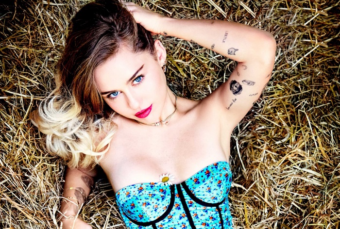 Miley Cyrus lying on hay