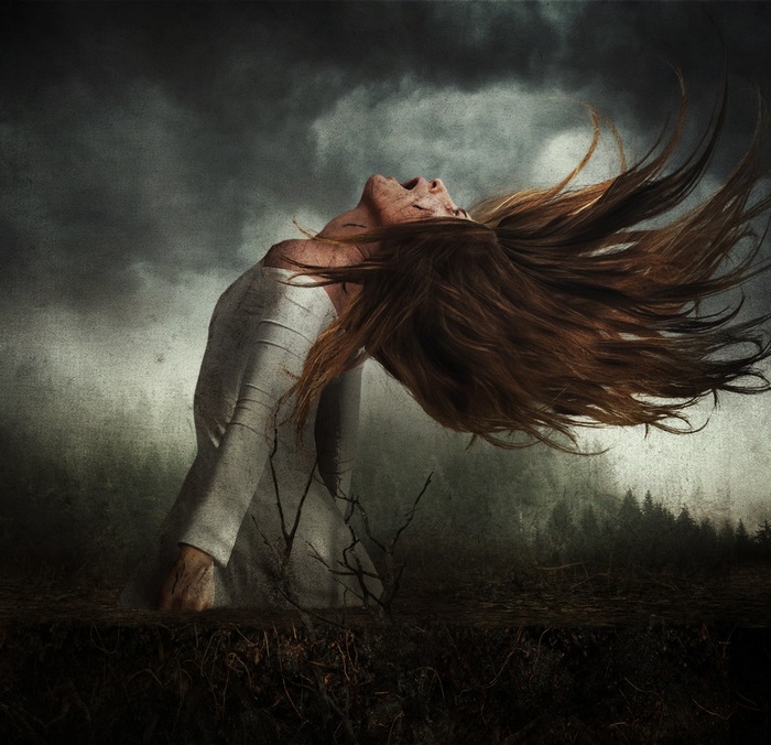 Woman screaming with hair flying in dark forest