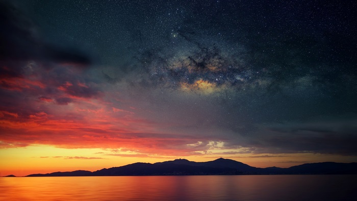 Island silhouette under the Milky Way and sunset