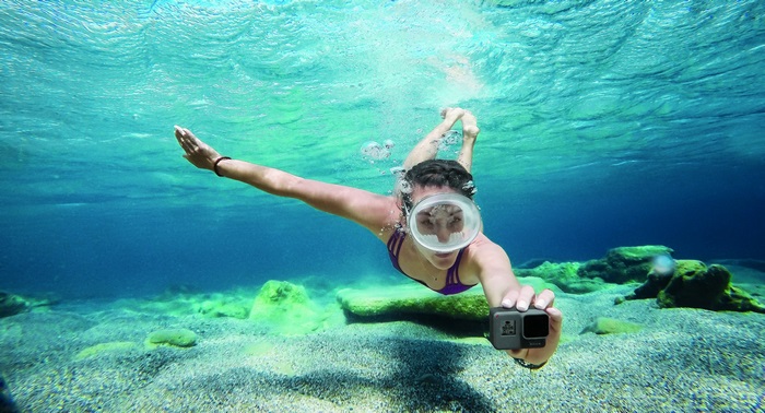 Woman snorkeling and filming with GoPro Hero 5