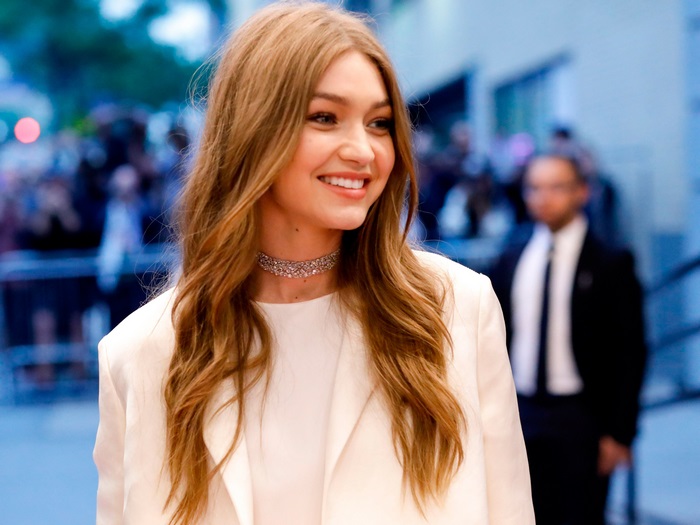 Gigi Hadid wearing a white blazer and choker