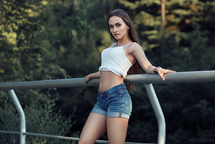 Woman in white tank top and denim shorts