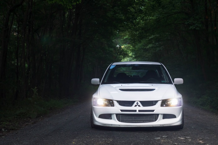 White Mitsubishi Lancer Evolution VIII on a forest road