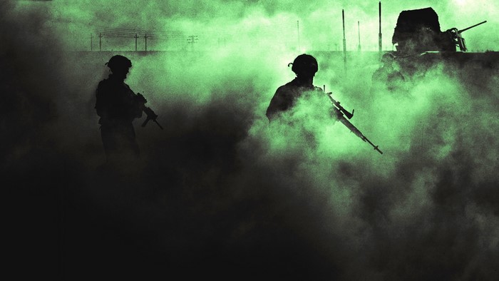Soldiers in smoke with military vehicle