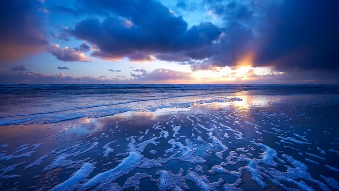Beach sunset with ocean waves and clouds