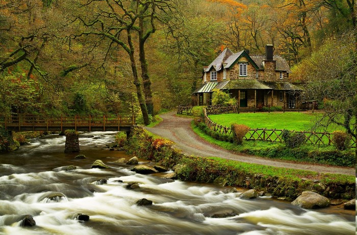 Stone house by a river and bridge in autumn forest