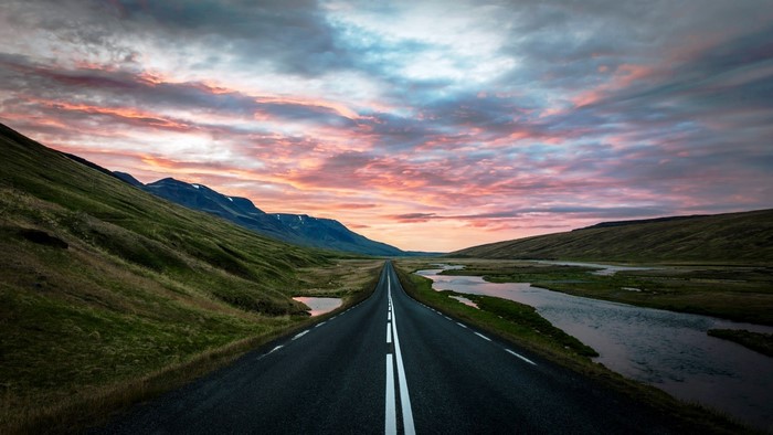 Road through Iceland landscape at sunset