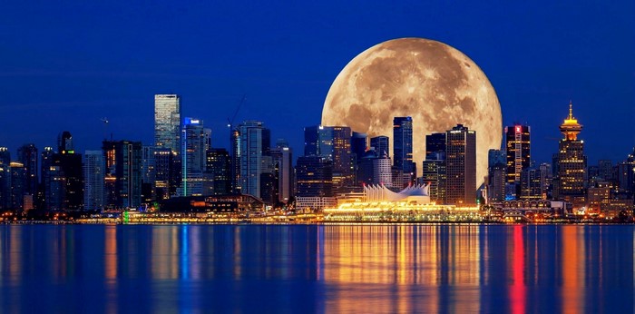 Vancouver cityscape with a large moon over the water