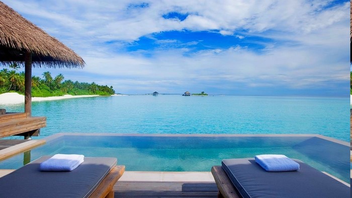 Infinity pool overlooking tropical beach and ocean