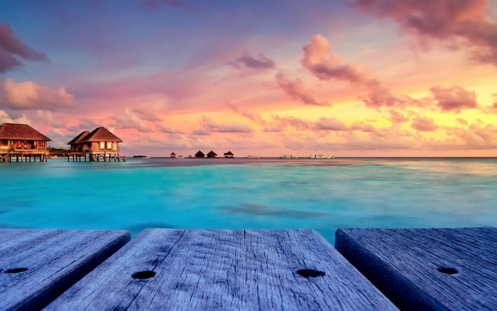 Bungalows on stilts in the Maldives at sunset