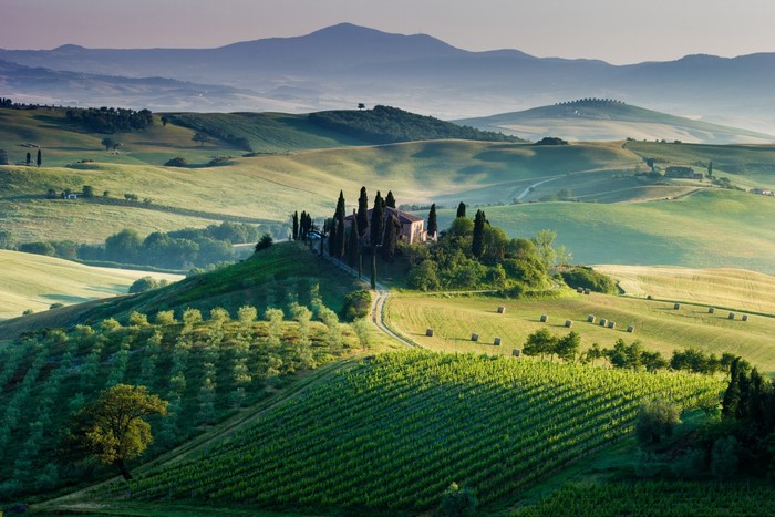 Tuscan landscape with rolling hills and a farmhouse