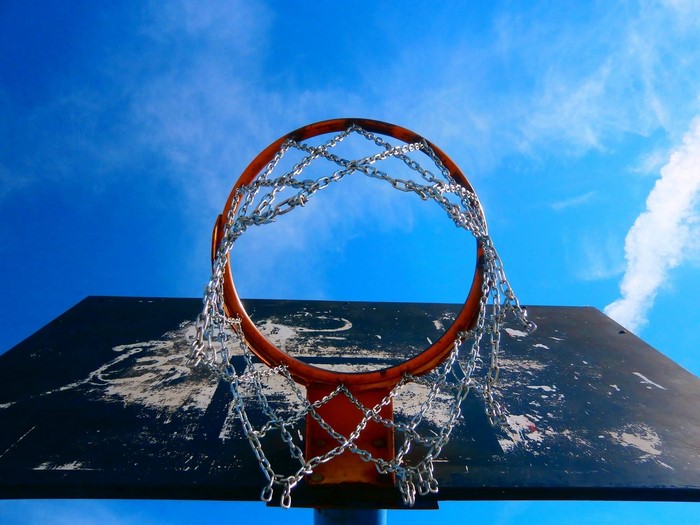 Basketball hoop with chain net against blue sky
