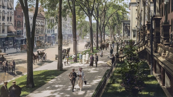 Colorized vintage street scene with horse-drawn carriages and pedestrians