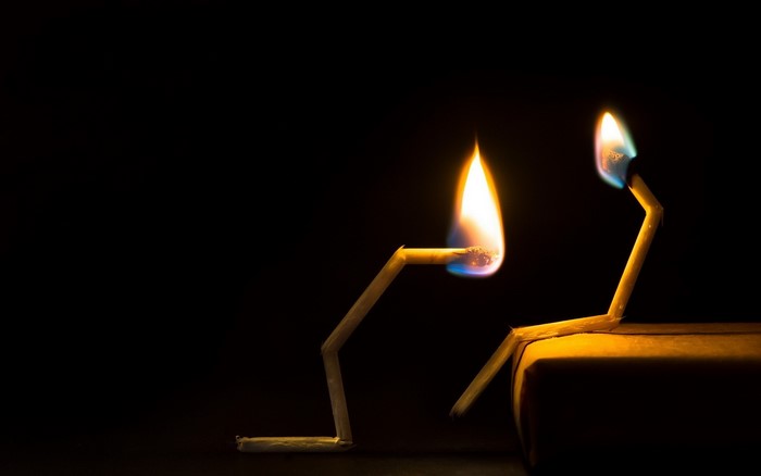 Two burning matches in the dark