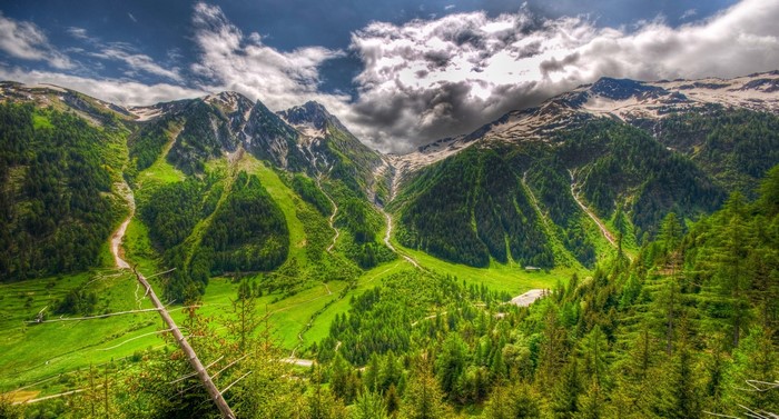 Mountain valley with green slopes and snow-capped peaks