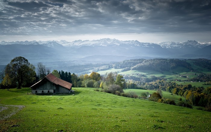 Peaceful countryside with green meadow and distant mountains