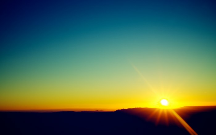 Sunset over mountains with lens flare