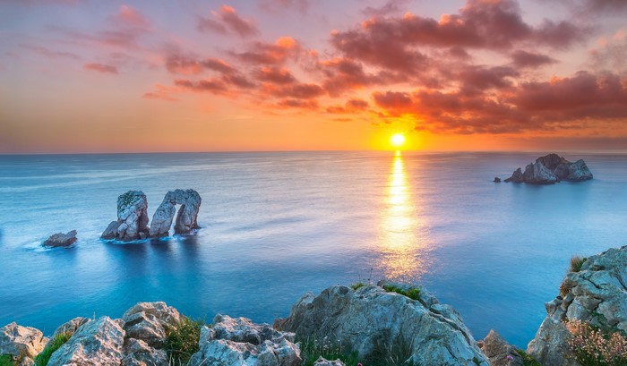 Sunset over the ocean with rock formations in Spain