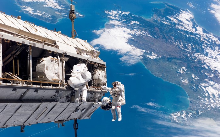 Astronauts performing spacewalk outside the International Space Station