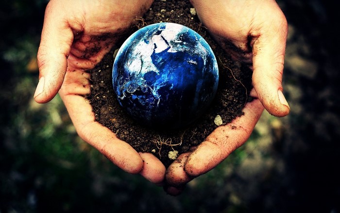 Earth planet held in hands with dirt