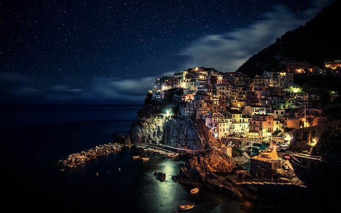 Manarola village at night with starry sky and sea