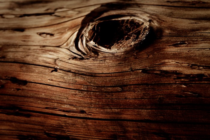 Close-up of weathered wood grain with a knot