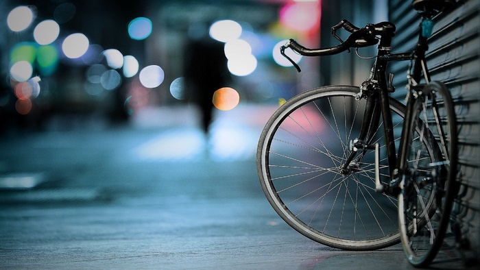 Bicycle leaning against a wall at night