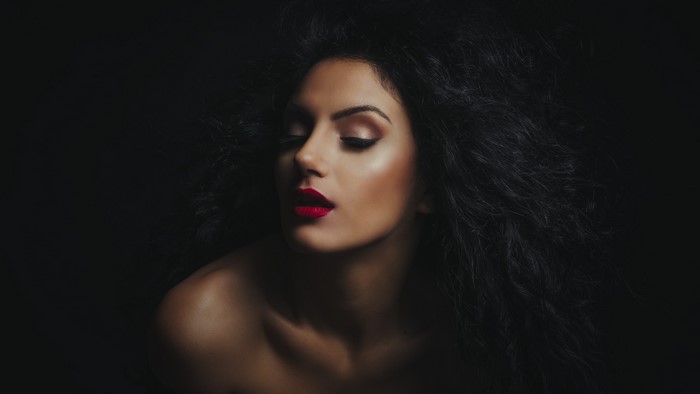 Woman with wavy black hair and red lipstick