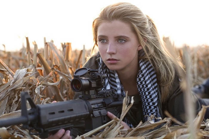 Woman with rifle in cornfield