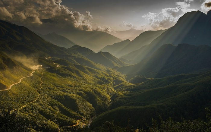 Sun rays over a mountain valley with a winding road in Vietnam