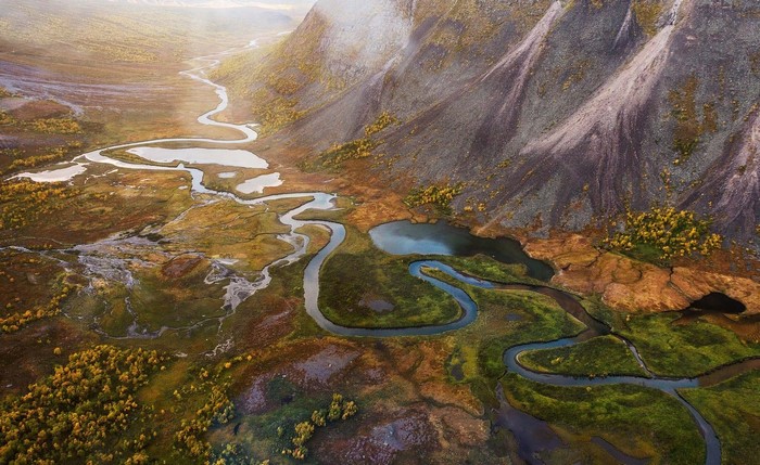 Aerial view of a winding river valley in fall