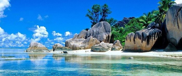 Tropical beach with large granite boulders and clear blue water