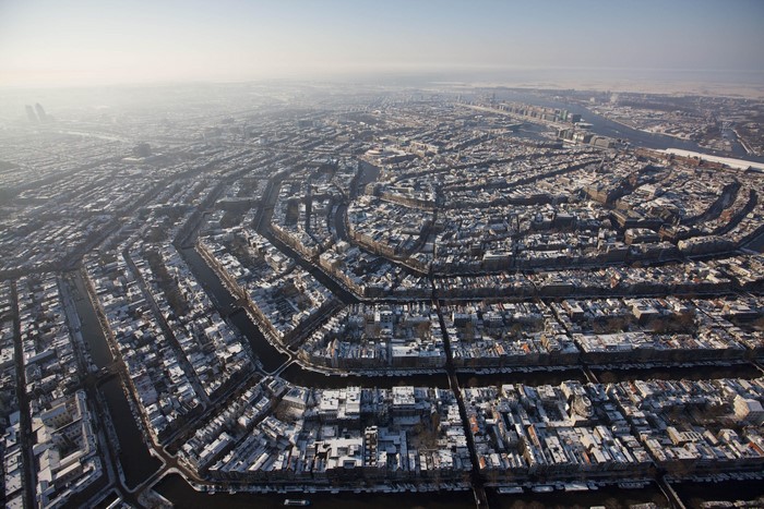 Amsterdam cityscape with canals and snow in winter