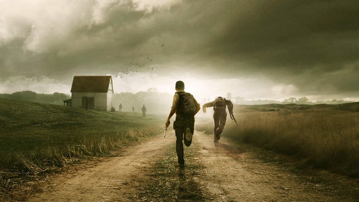 Two people running on a dirt road with a barn in the background