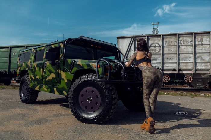 Woman in camouflage posing with a Hummer