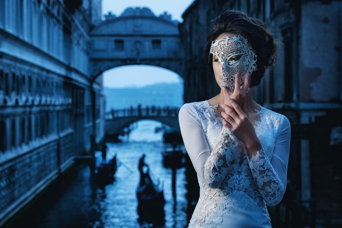 Woman in mask in Venice with gondolas