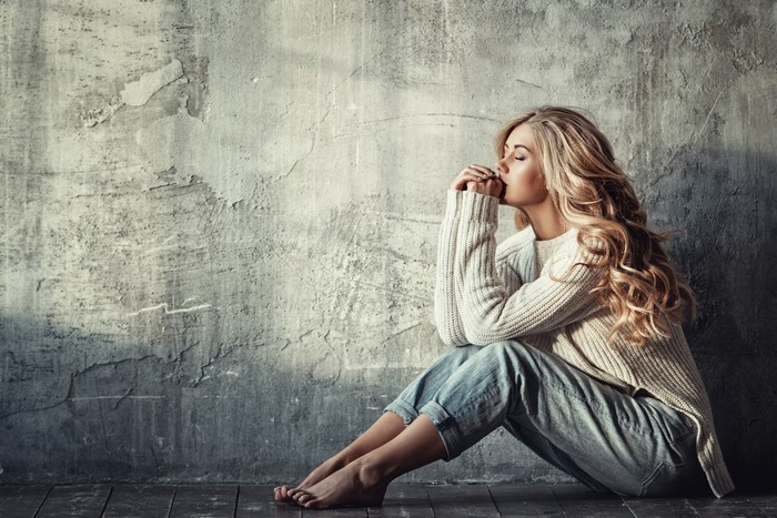 Woman with blonde hair sitting on floor